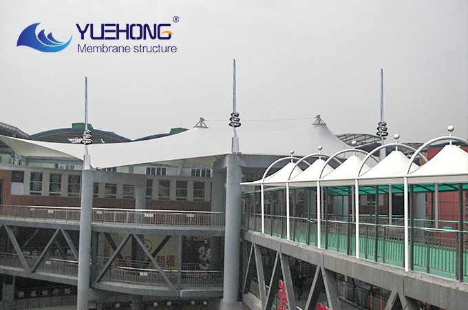 On rainy days, membrane-structured sunshade and rain canopies uphold the “warm, people-centered spirit” of the city
